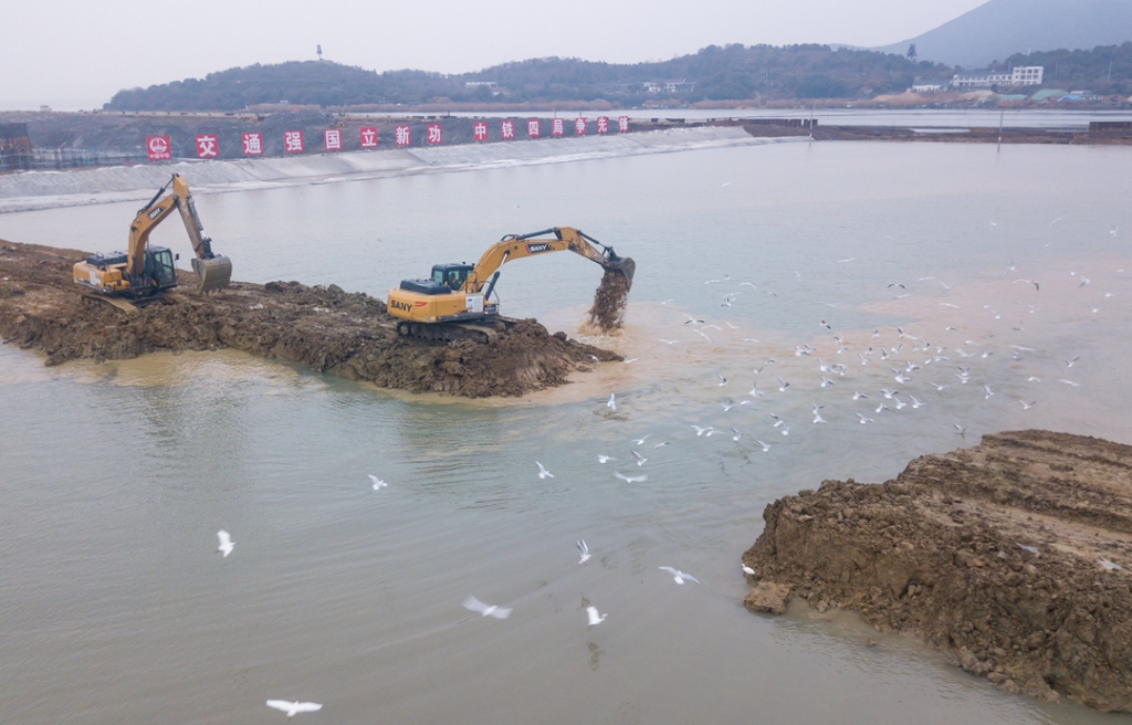 2019年12月23日，鳥群從陸島轉(zhuǎn)換圍堰回水施工現(xiàn)場飛過。